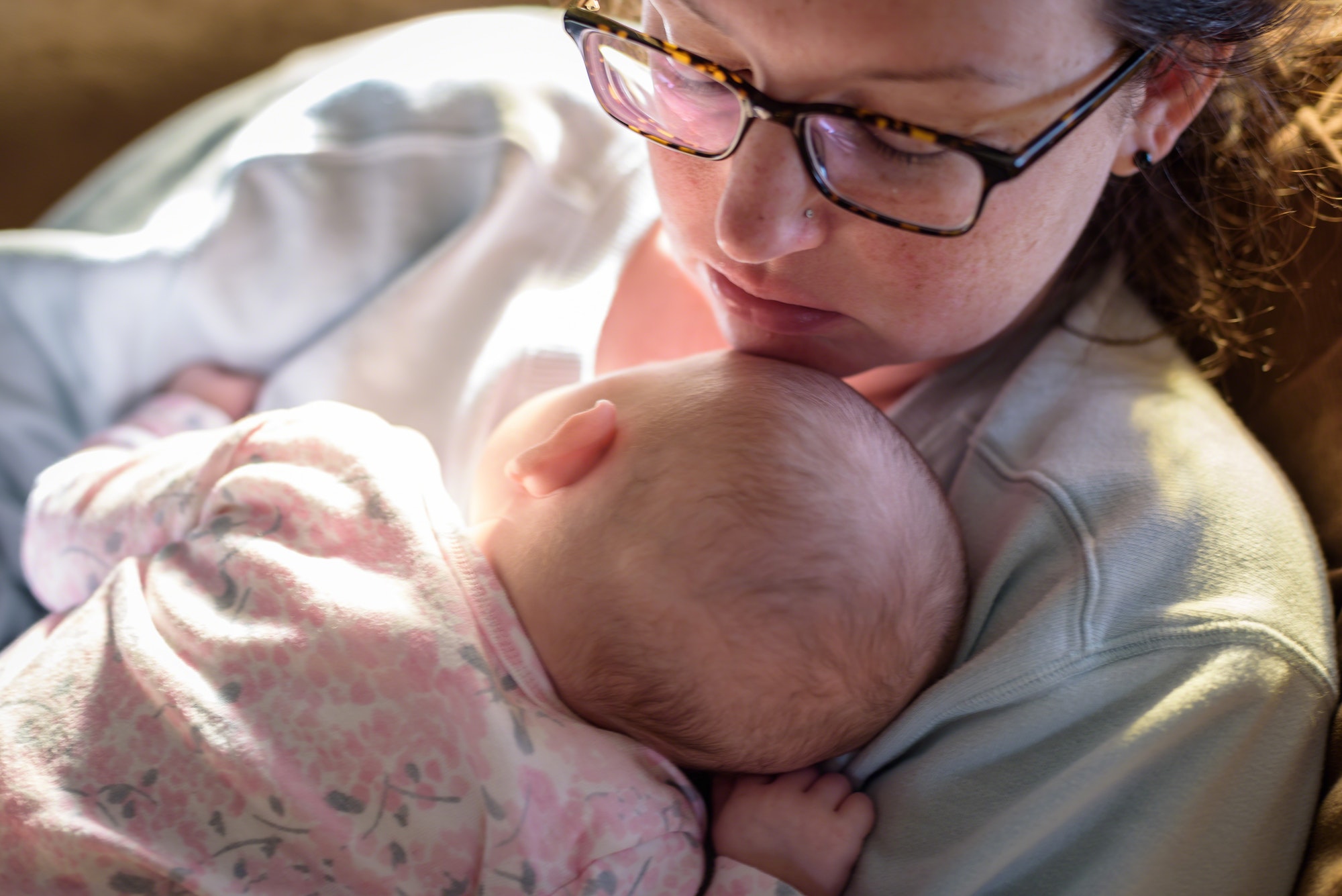New mom napping with newborn baby in early morning
